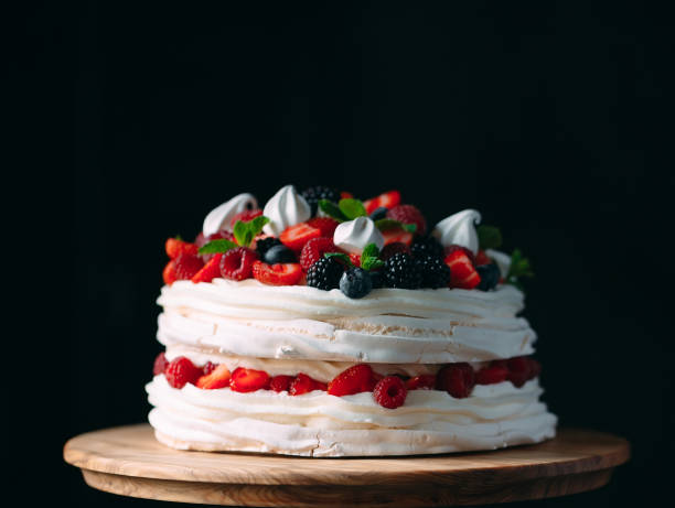 istock Fruit cake. Cake decorated with berries on a wooden stand on a black background. 1268392755