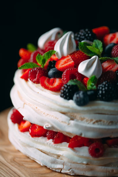 istock Fruit cake. Cake decorated with berries on a wooden stand on a black background. 1268392760