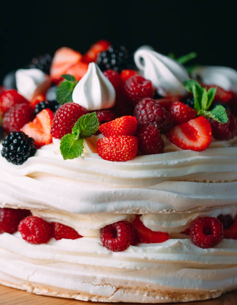 istock Fruit cake. Cake decorated with berries on a wooden stand on a black background. 1268392768