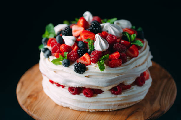 istock Fruit cake. Cake decorated with berries on a wooden stand on a black background. 1268392787