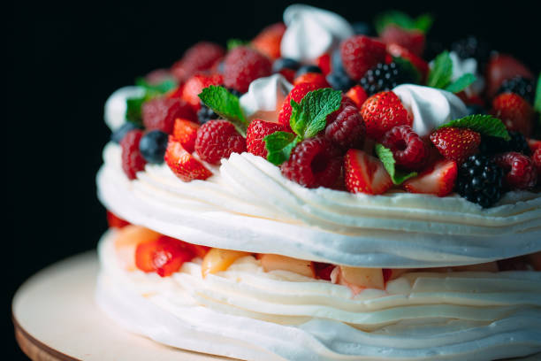 istock Fruit cake. Cake decorated with berries on a wooden stand on a black background. 1268392845