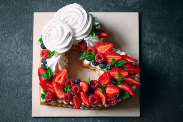 istock Fruit cake. Cake decorated with berries on a wooden stand on a black background. 1268393551