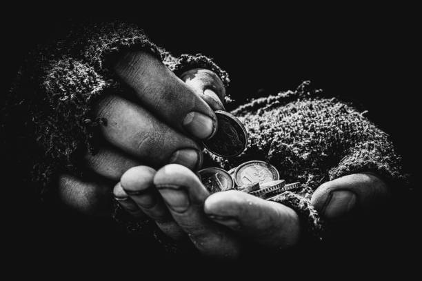 The beggar's hands are dirty, and there are a few cents in them. The beggar's hands are dirty, and there are a few cents in them. Men's hands in old torn gloves hold Euro cents, poverty. A beggar asks alms, a black and white photo. beg alms stock pictures, royalty-free photos & images