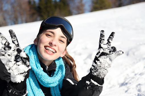 Young cheerful girl having fun in the snow