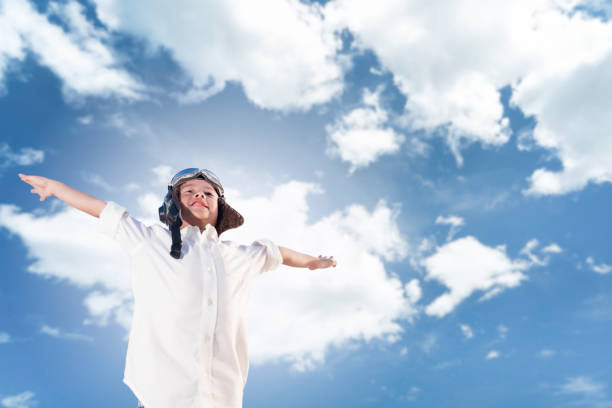 istock Asian boy in aviator hat posing flying pretending pilot on sky background 1268394651