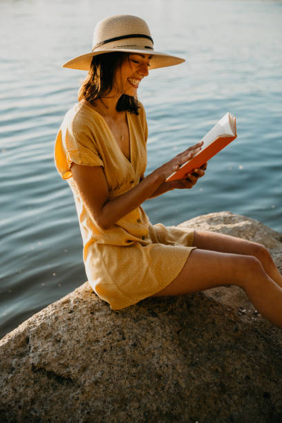 istock Pensive attractive Caucasian brunette sitting with a book 1268395589