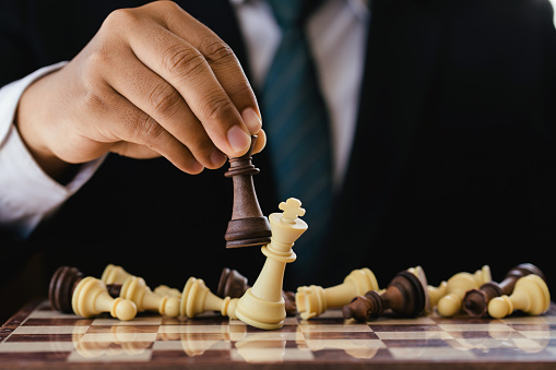businessman hand moving chess figure in competition success play. strategy,leader and teamwork concept for success.