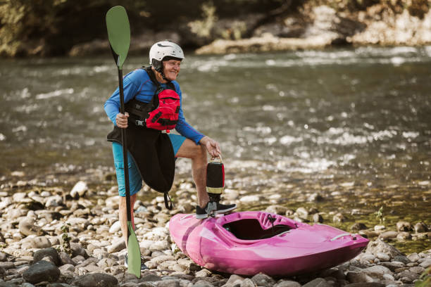 istock Senior man preparing for kayak tour on a mountain river. 1268397885