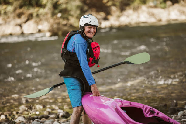 istock Senior man preparing for kayak tour on a mountain river. 1268398055