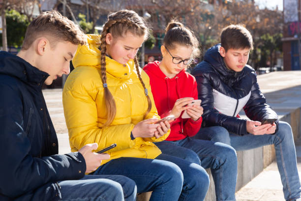 istock Teens with phones outdoors 1268399549