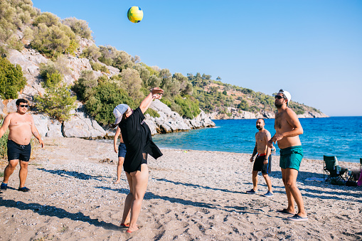 group of friend play volleyball on the beach
