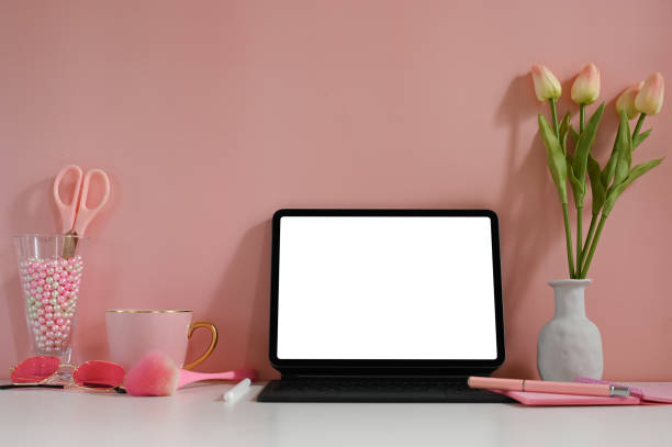 istock A computer tablet with a white blank screen is putting on a working desk surrounded by various equipment. 1268404423