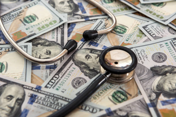 istock Doctor or nurse stethoscope on dollar banknotes 1268404732