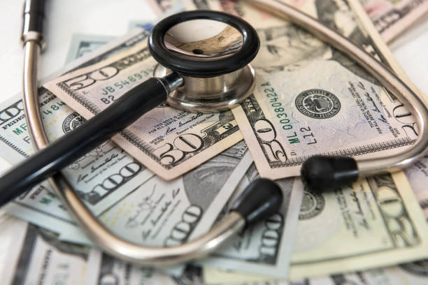 istock doctor stethoscope lying on a lot of  Dollar banknotes 1268404884