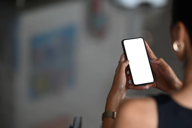 istock A beautiful woman is using a mobile phone while sitting in the living room. 1268406818