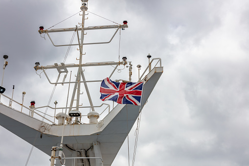 Great Britain's flag waving in the wind on the ship's mast.