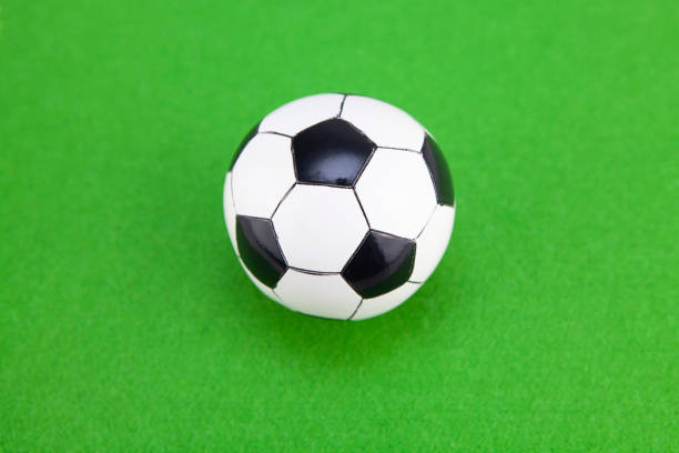 istock Mini soccer balls on green felt surface 1268412096