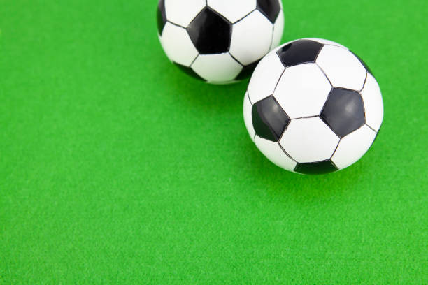 istock Mini soccer balls on green felt surface with copy space 1268412604