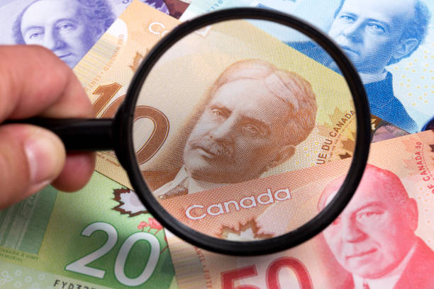 istock Canadian dollars in a magnifying glass 1268412618