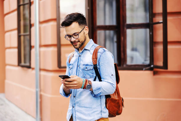 istock Young attractive hipster standing outdoors and using smart phone. 1268415969
