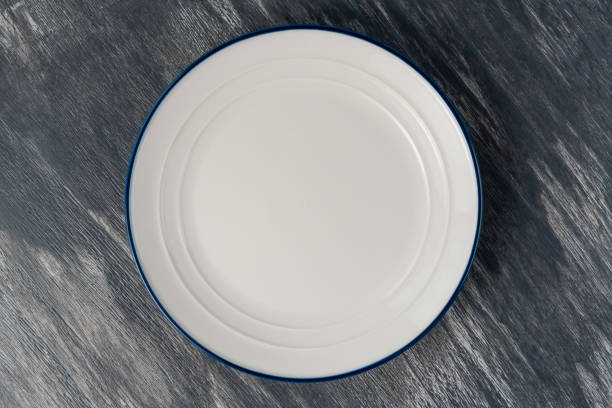 istock White plate with a blue border on the gray wood artistic plank 1268416122