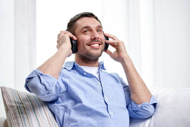 istock smiling young man in headphones at home 1268416205