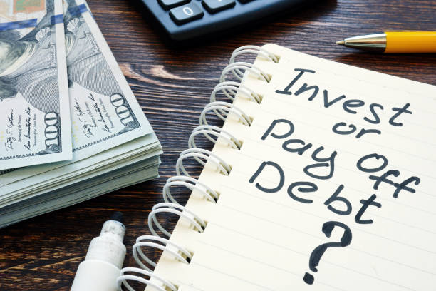 istock Invest or pay off debt question in the notebook. 1268417781