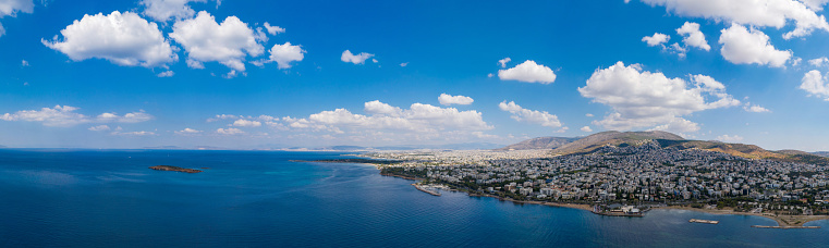 Athens Greece riviera panorama. Aerial drone view of Voula and Glyfada coastline, high class residential distric. Cloudy blue sky over sea water, sunny summer day