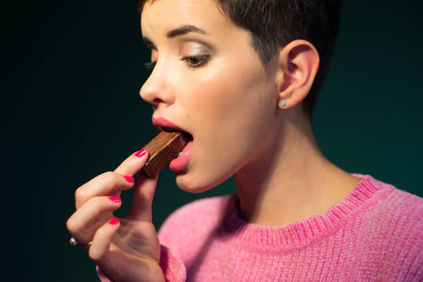 istock Woman eating chocolate 1268430653