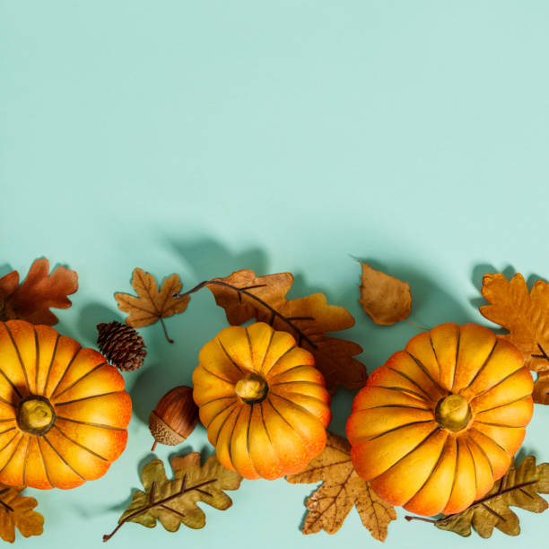 istock Autumn background creative layout with decorative small pumpkins and autumn leaves 1268431478