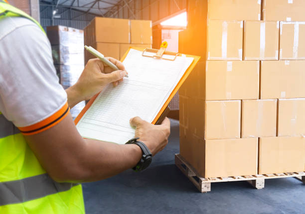 istock Cargo freight industry warehouse shipment transportation. Worker courier holding clipboard inspecting checklist control load cargo into a truck. 1268433079