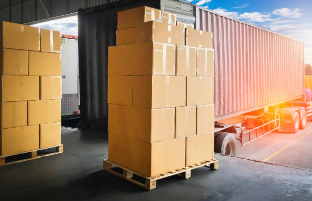 istock Road freight cargo delivery by truck. Stack of shipment boxes waiting for load into container truck at warehouse dock. Logistics and transportation 1268433139