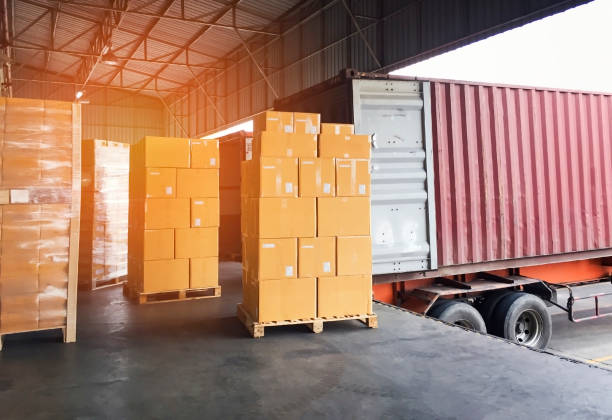 istock Road freight cargo delivery by truck. Stack of shipment boxes waiting for load into container truck at warehouse dock. Logistics and transportation 1268433532