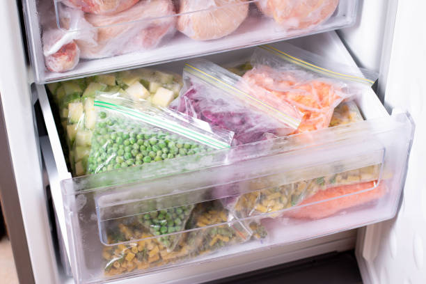 assortimento di verdure surgelate in frigo. alimenti surgelati nel congelatore - cibi surgelati foto e immagini stock