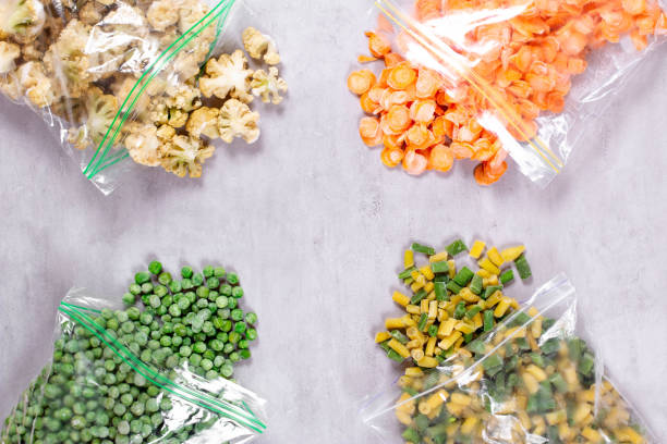 istock Frozen vegetables in plastic bags on concrete background, top view 1268433775