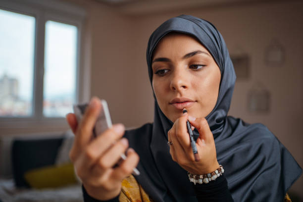 hermosa mujer musulmana que aplica maquillaje - lip liner fotografías e imágenes de stock