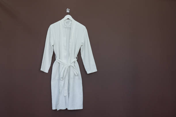 istock New white bathrobe isolated on brown background 1268438688