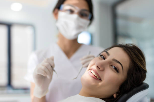 sonriendo paciente en la silla del dentista y mirando a la cámara - young women smiling women human teeth fotografías e imágenes de stock