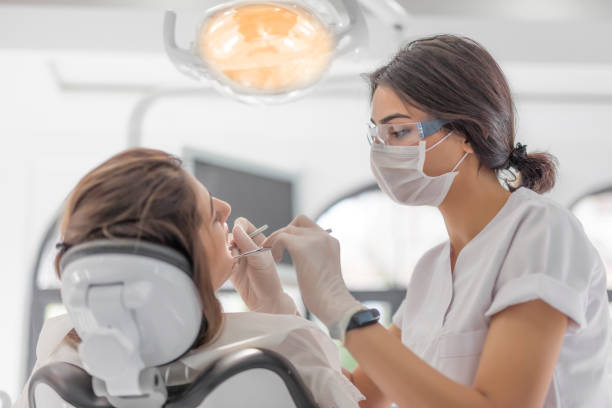 zahnärztin untersucht ihre patientin in der zahnklinik - zahnarzt stock-fotos und bilder