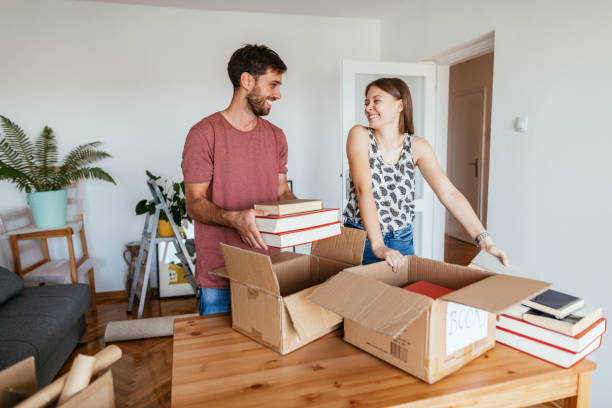 istock Students moving to new shared apartment, unboxing books from boxes 1268441852