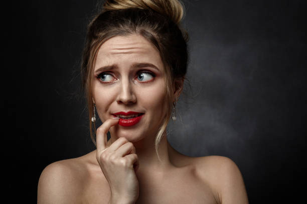 stressed fun girl stressed fun girl with finger on mouth on black background looking aside irony stock pictures, royalty-free photos & images