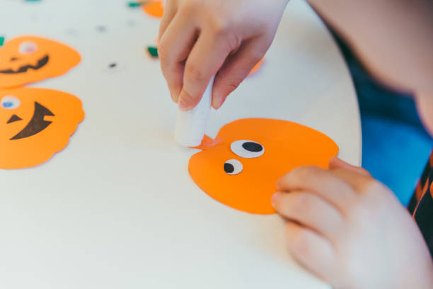istock little boy making pumpkins head from paper 1268445130