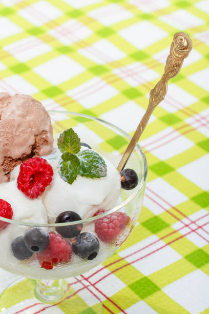 istock White and chocolate ice cream in a glass with raspberry and currant berries 1268446594