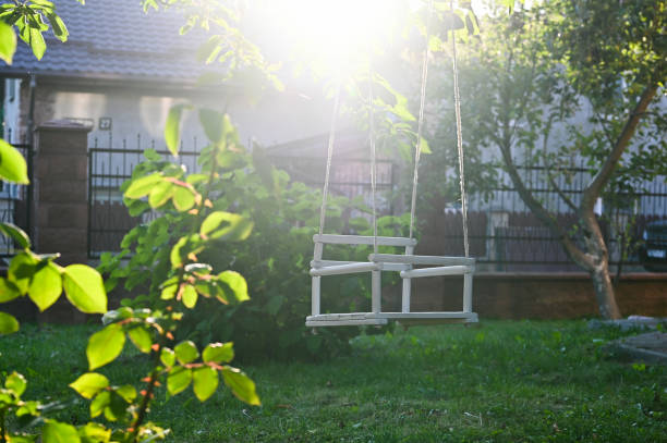 istock baby white hanging swing on grass background 1268446617
