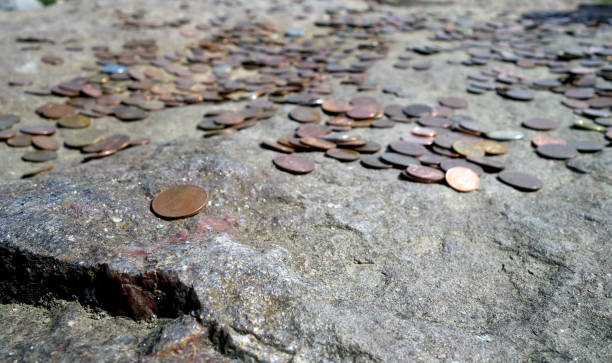 istock Metal coins on old stone symbolizm. 1268446634