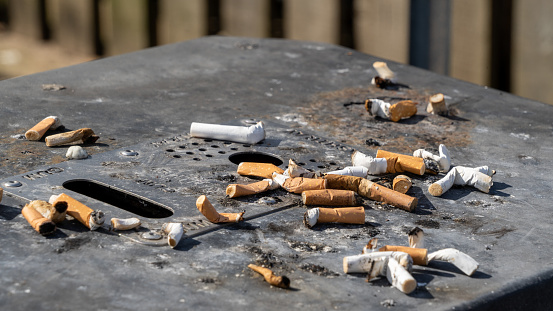 Pile of cigarette butt in ashtray on restaurant table