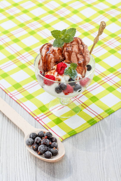 istock Chocolate and white ice cream in a glass with raspberries and currants 1268447203