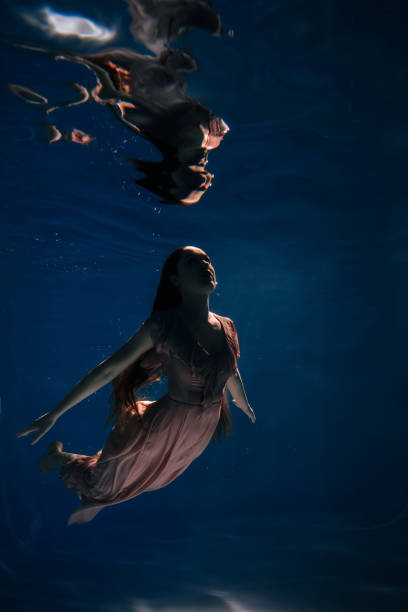 istock Woman Swimming Night Ocean Underwater Active Time 1268449486
