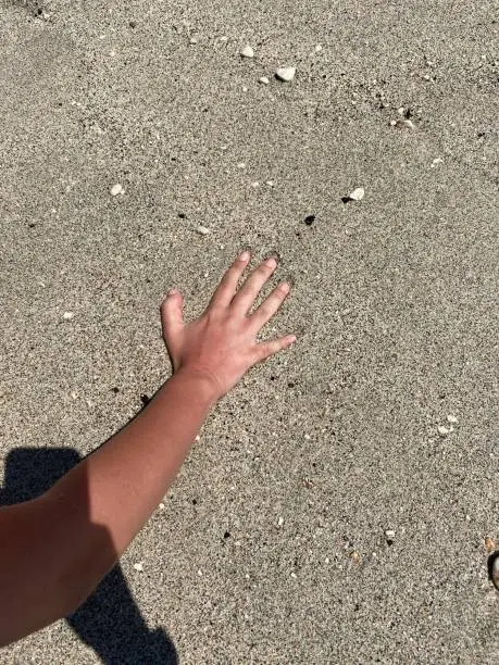 Kum plajda elinin izini bırakmak. Güzel kum plajda elini bastırmak