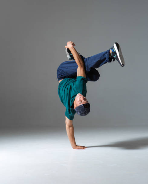 istock Cool b-boy dancing on the floor in studio isolated on gray background. Breakdancing school poster 1268452964